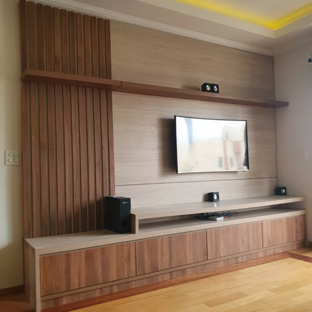 Sala de TV com painel ripado e móveis baixos